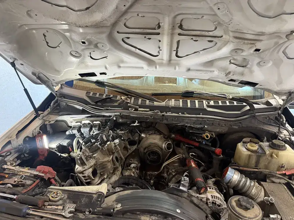 Top view of a diesel truck engine with the hood up and intake parts in view